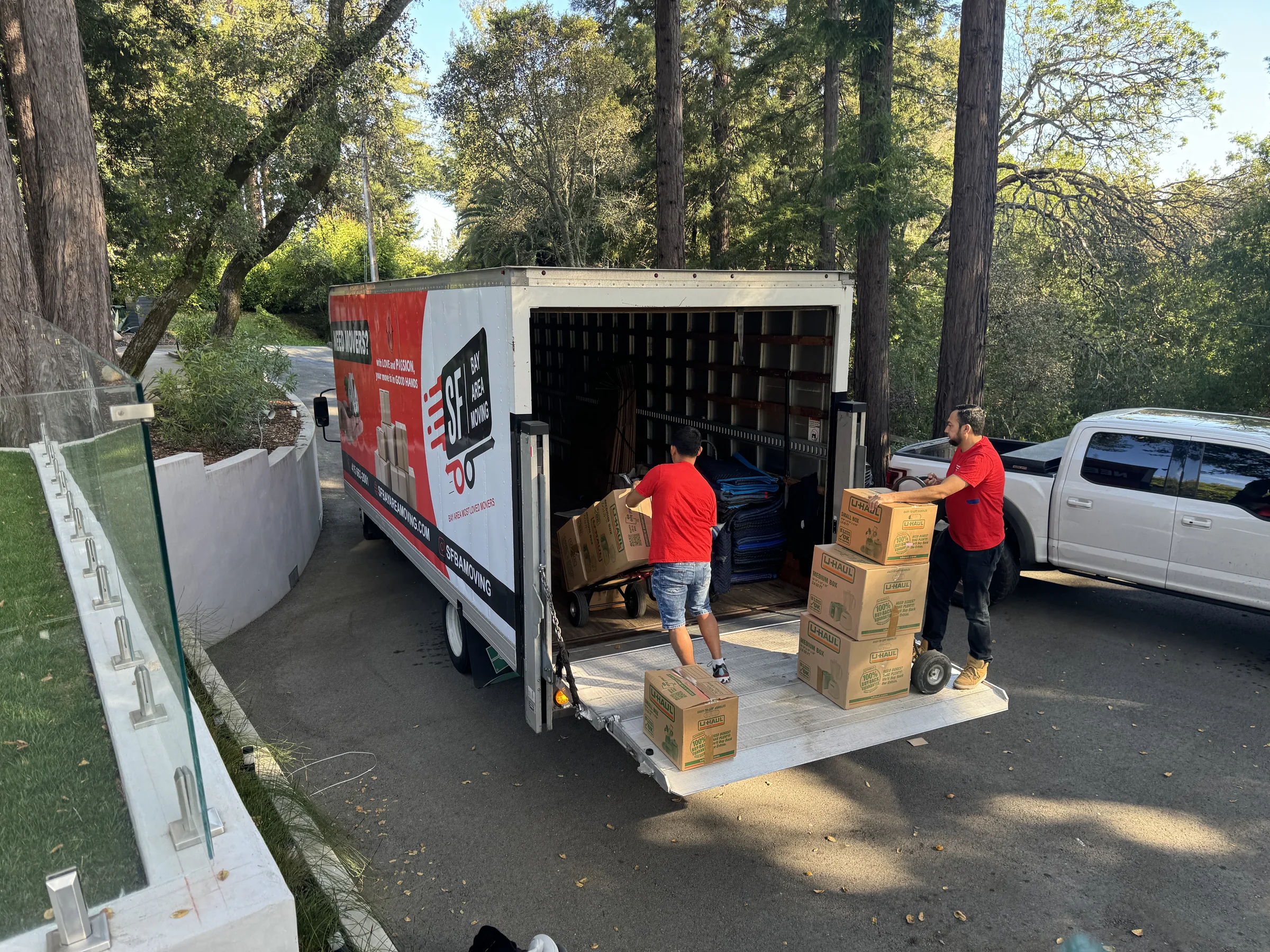 SF Bay Area Moving crew loading boxes into a truck from a residential driveway.