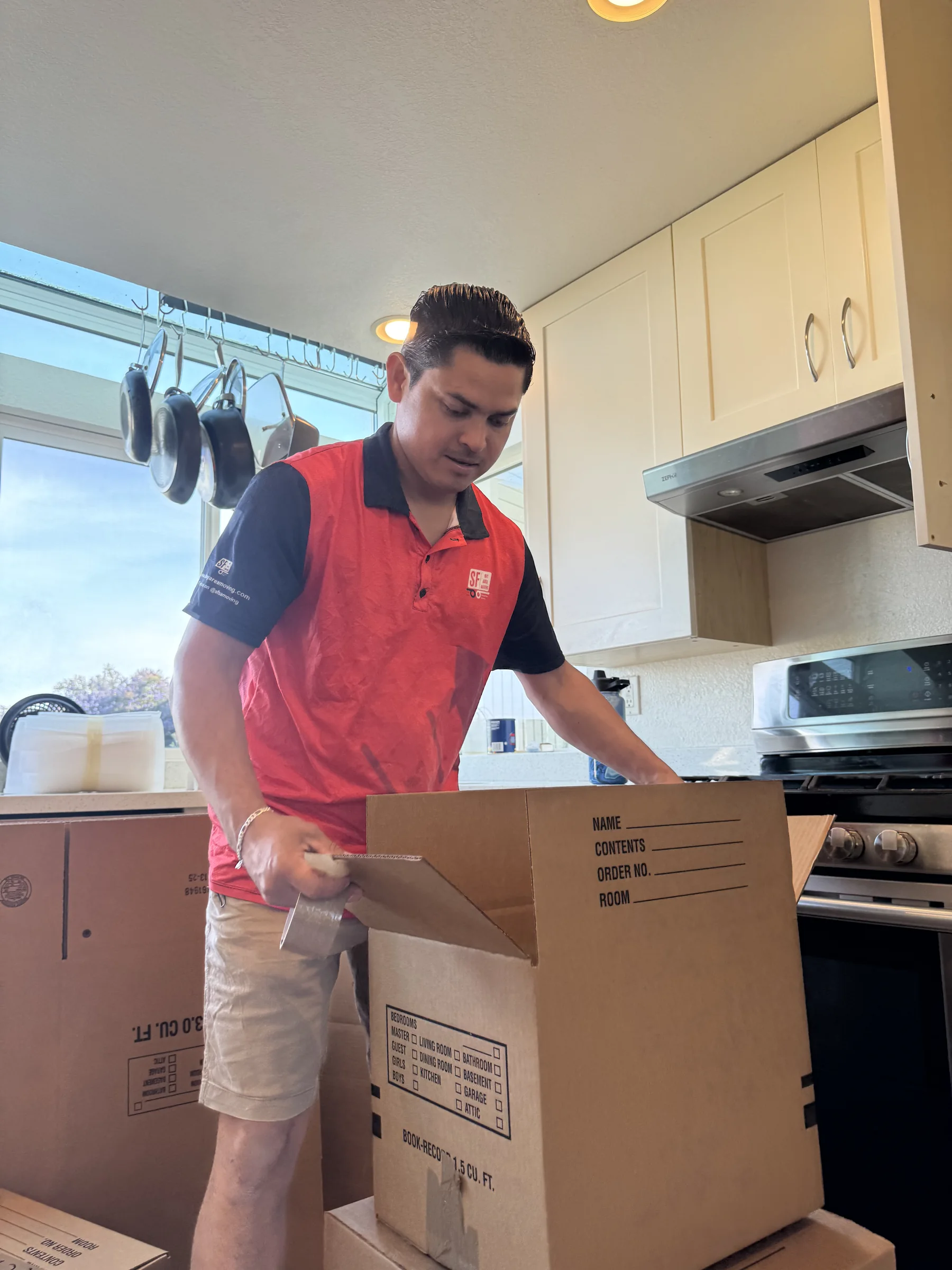 SF Bay Area Moving professional assembling a packing box in a kitchen.