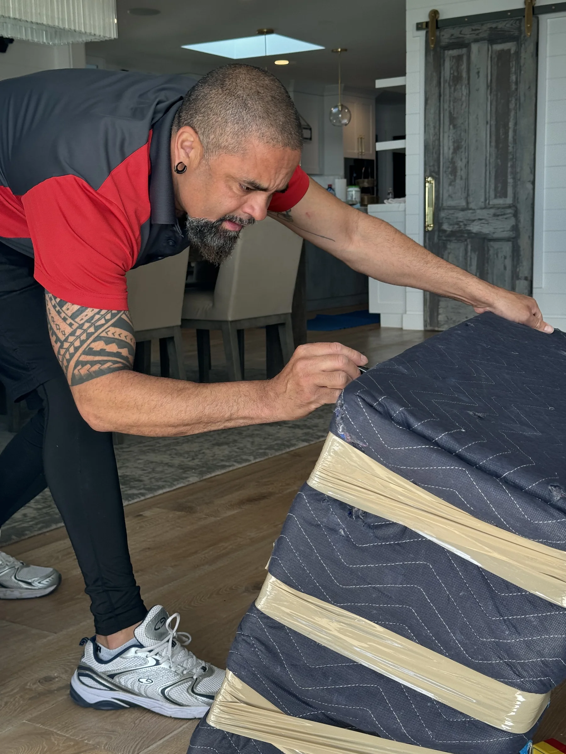 SF Bay Area Moving professional securing protective padding around a sofa.