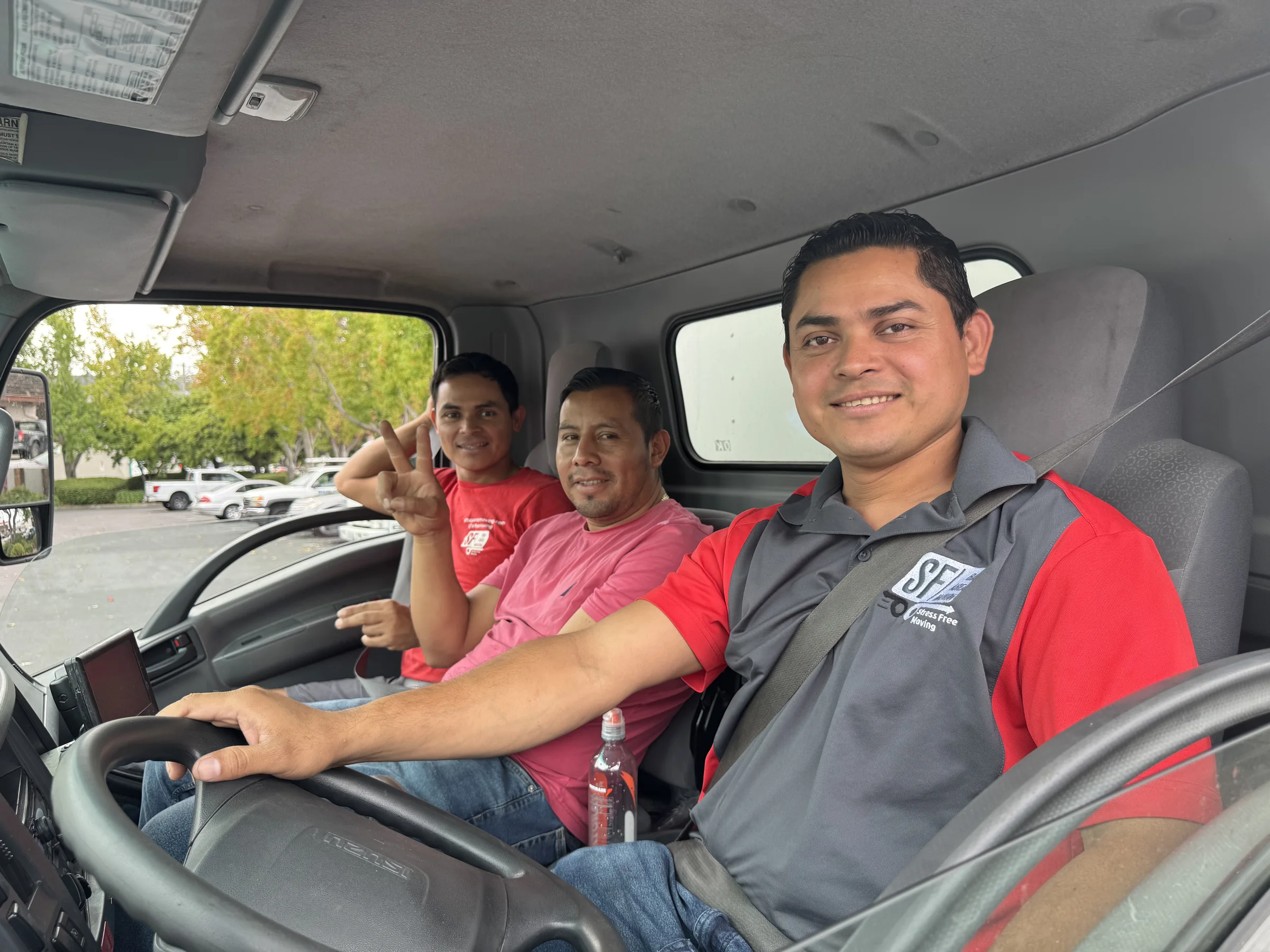 Three SF Bay Area Moving team members smiling inside the moving truck.